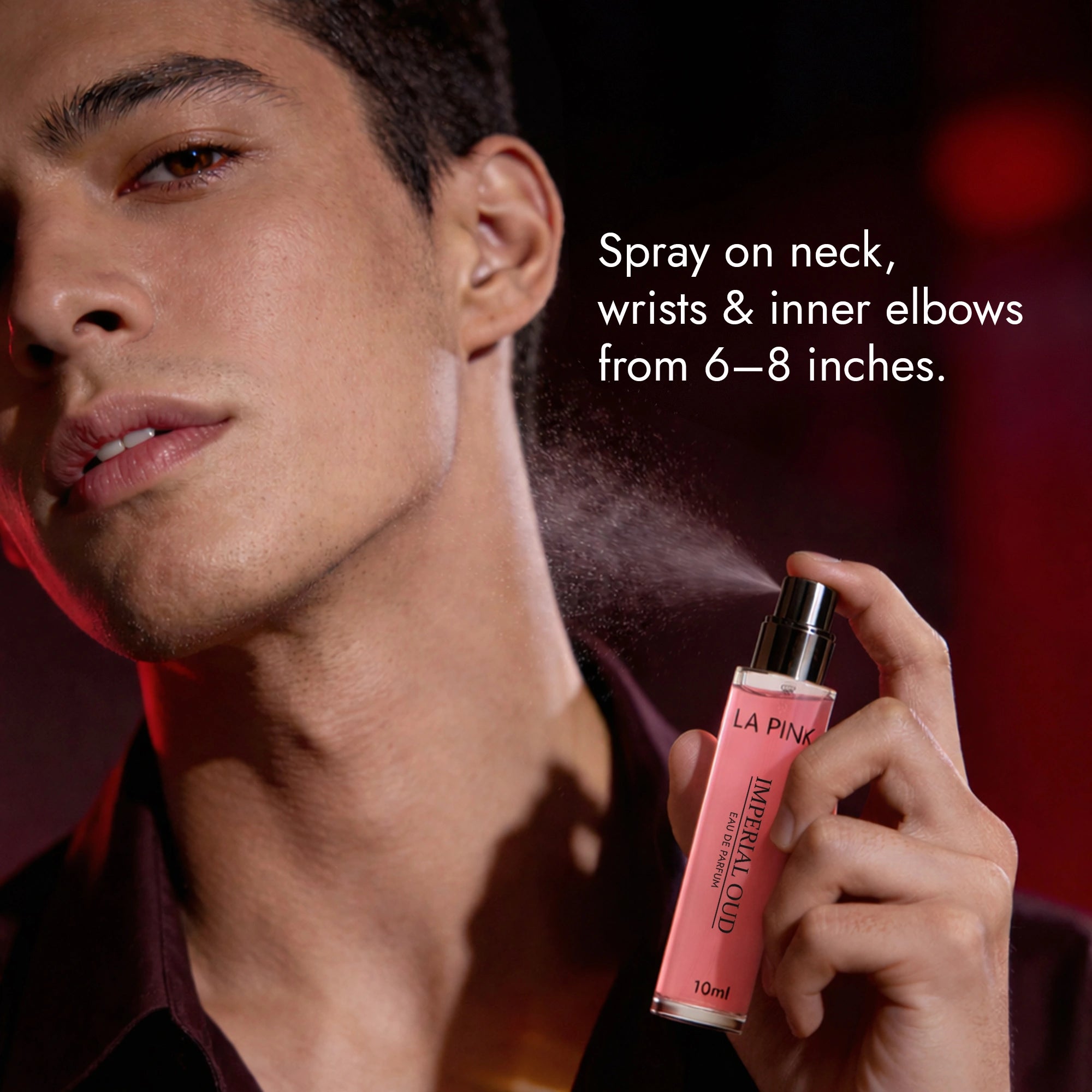 Man holding a pink spray bottle labeled &