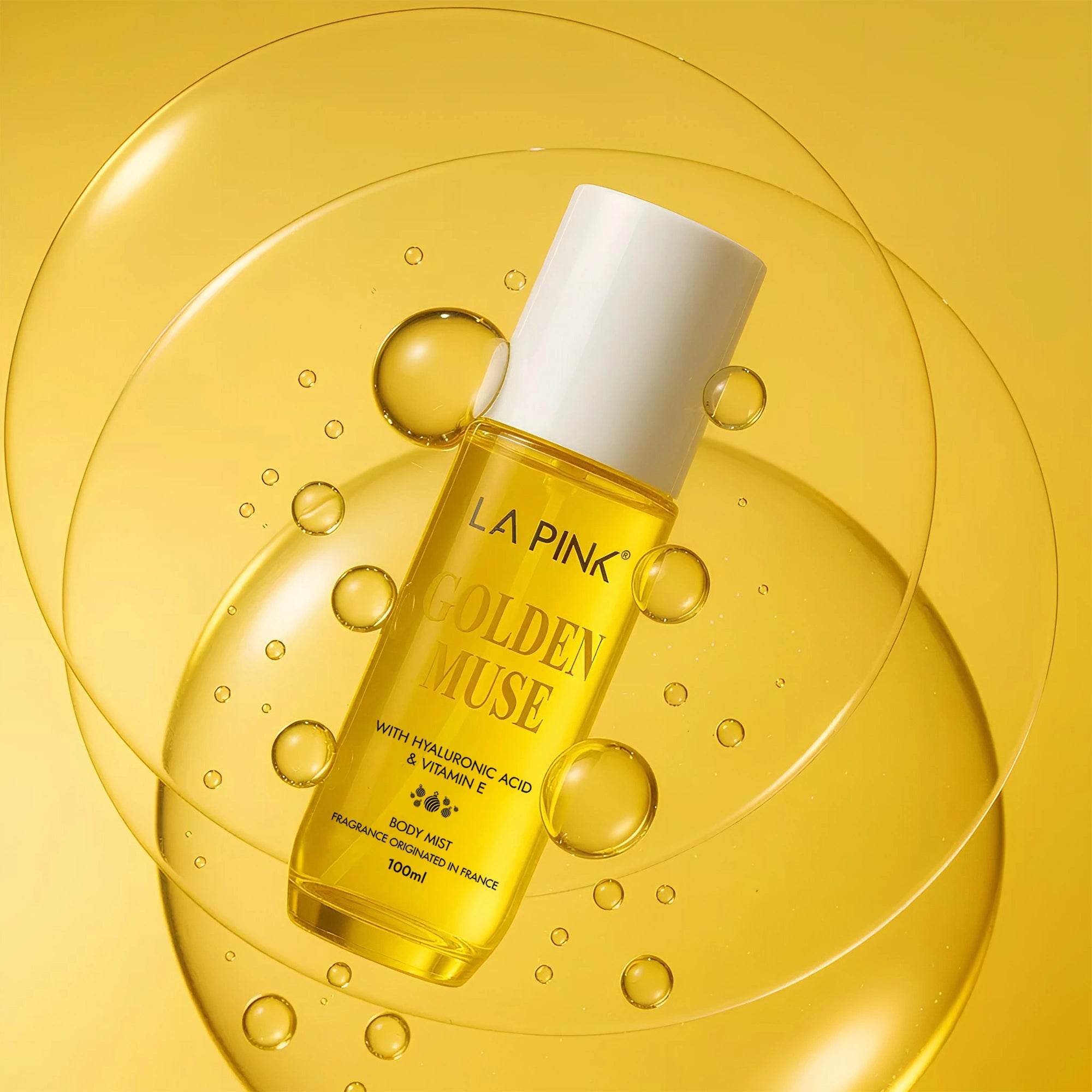 La Pink Golden Muse bottle on a yellow background with bubbles
