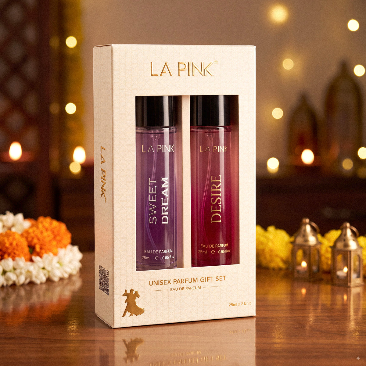 LA PINK Unisex Parfum Gift Set containing Sweet Dream and Desire bottles, presented in a cream-colored box on a wooden table with warm bokeh background lights.
