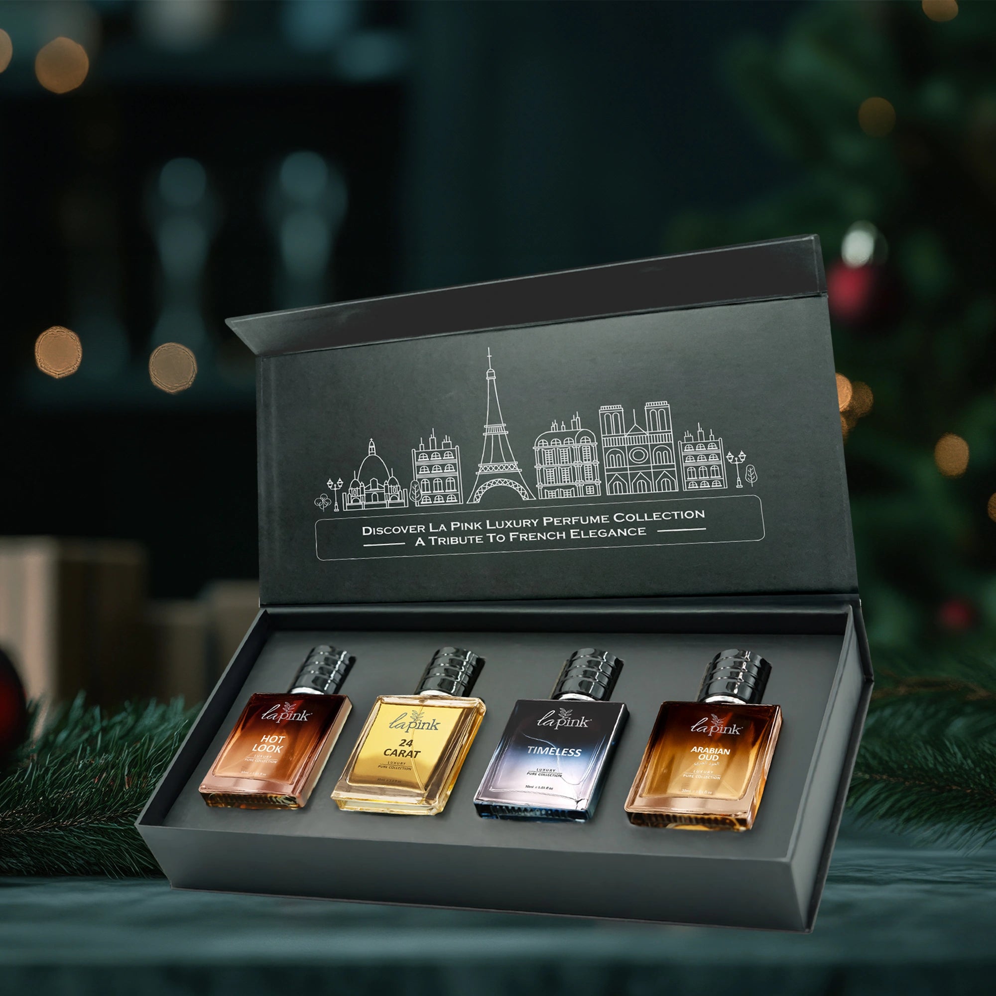 Set of four perfume bottles in a decorative box with Parisian skyline design on a festive background.
