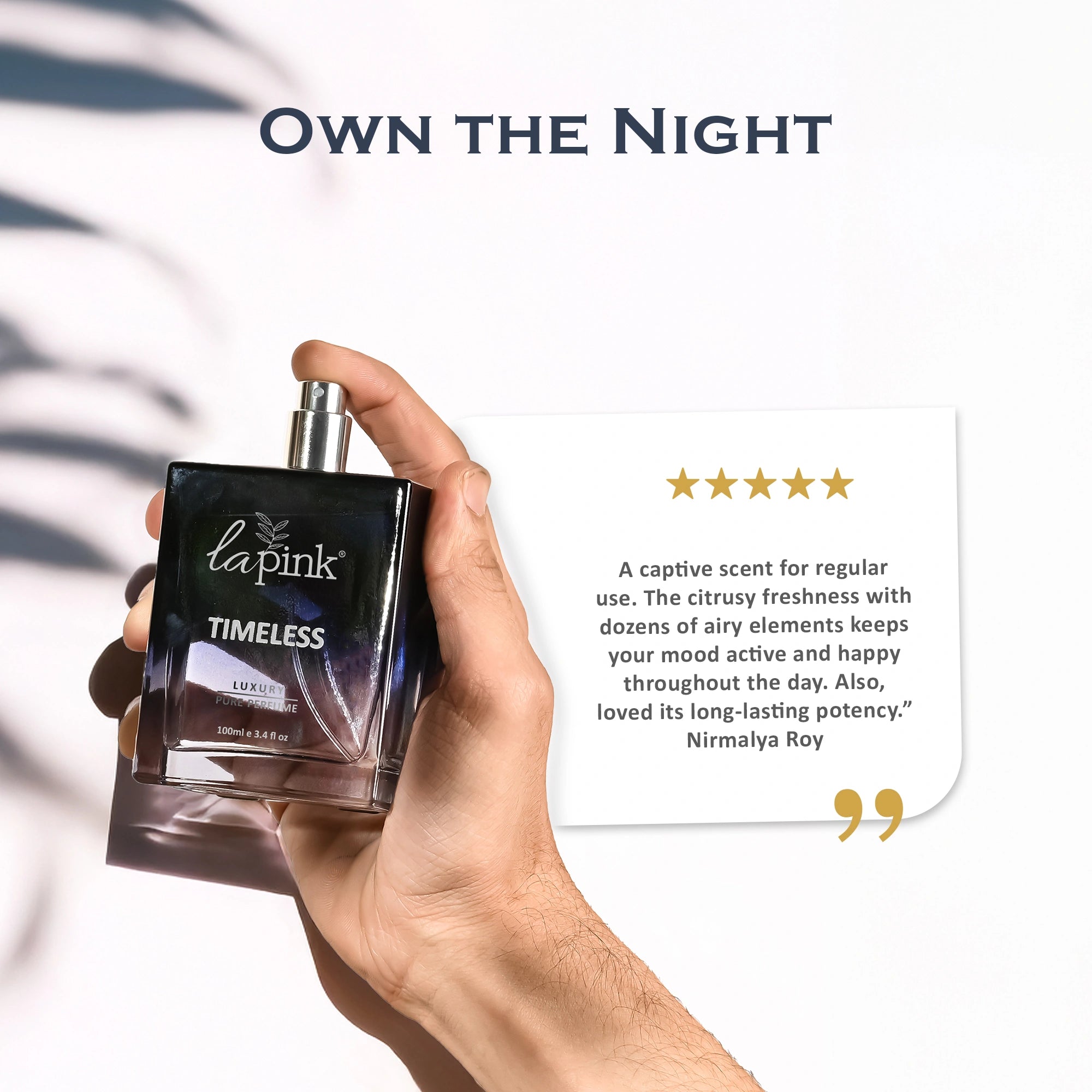 Hand holding a perfume bottle labeled &