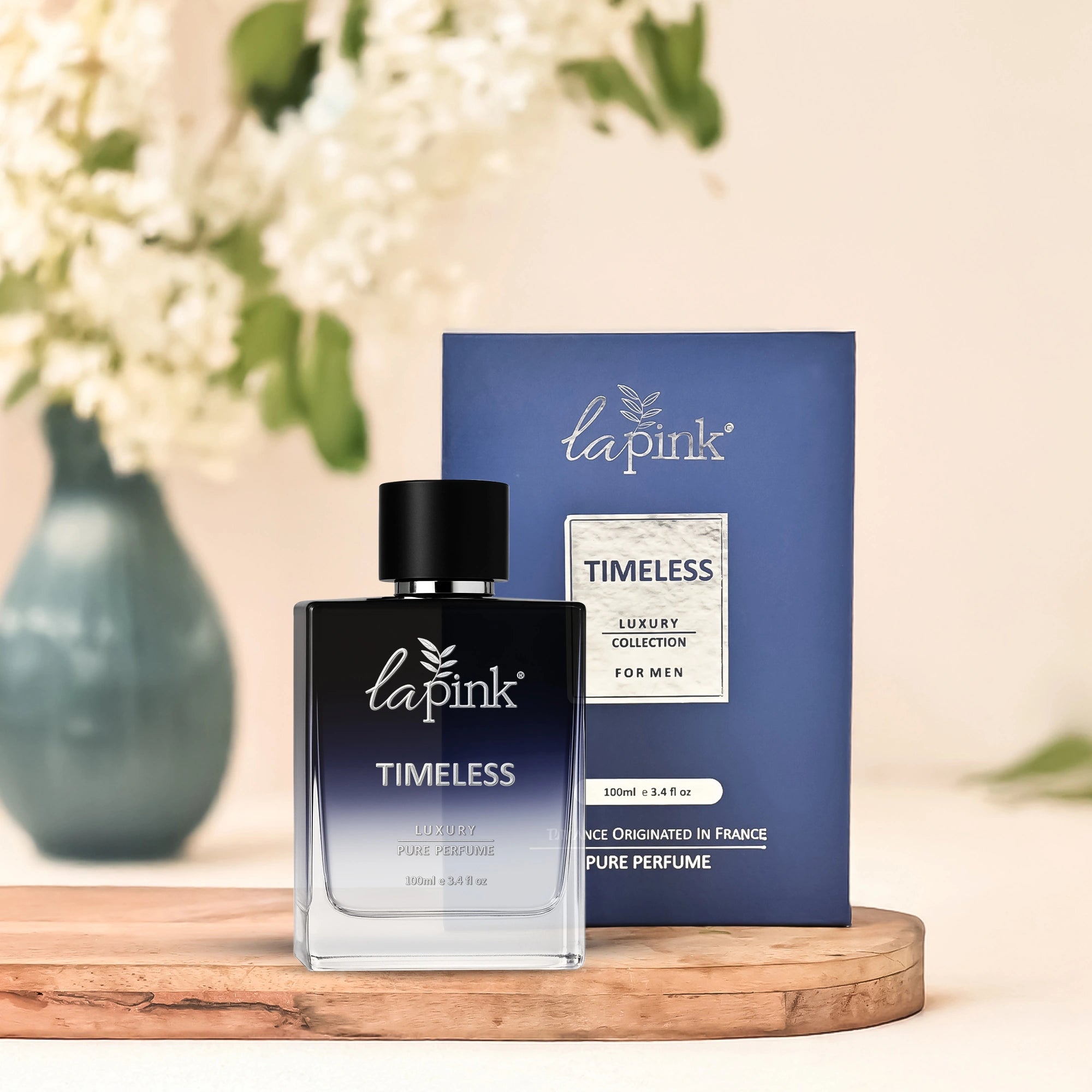 La Pink Timeless perfume bottle and packaging on a wooden surface with flowers in the background