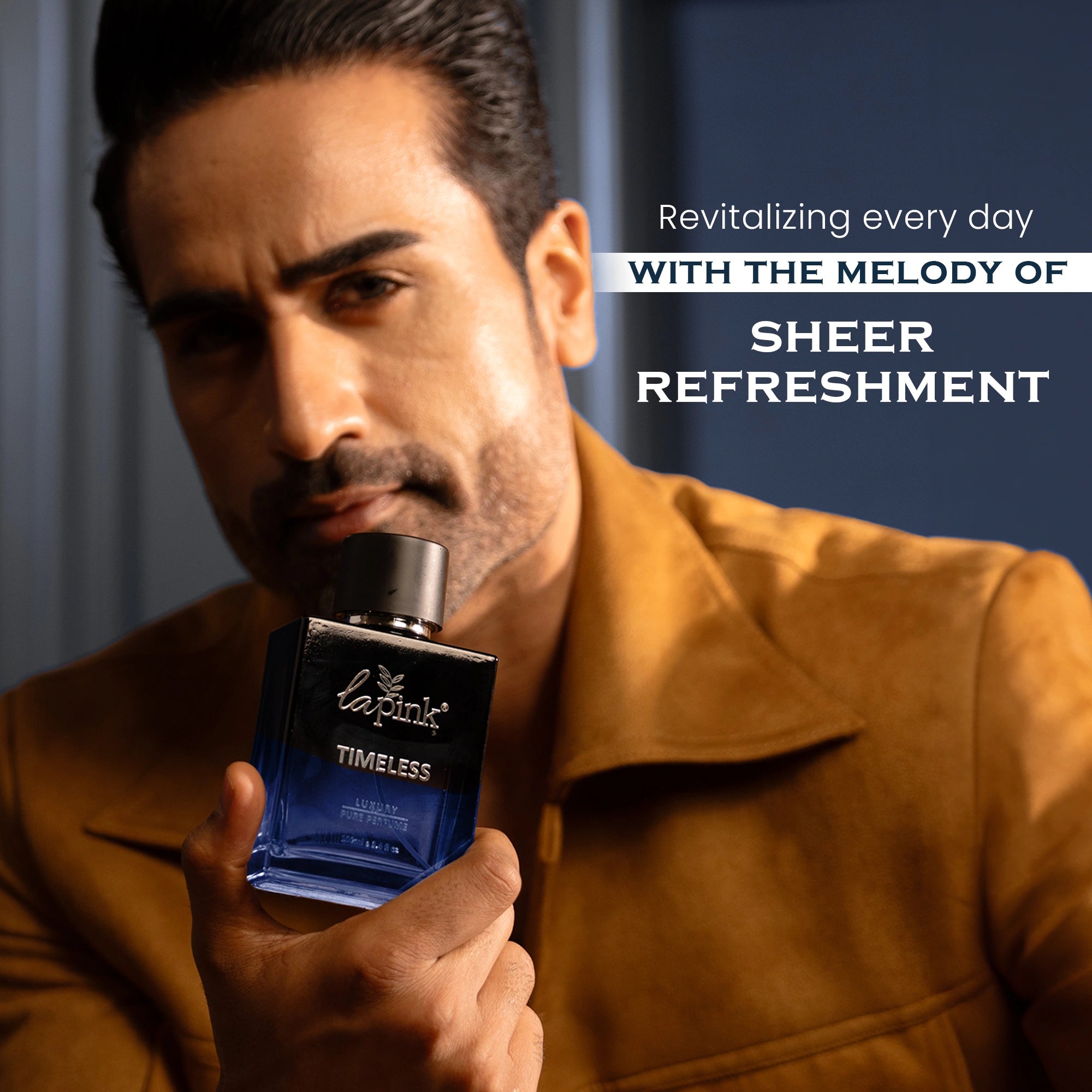 Man holding a blue perfume bottle with text about sheer refreshment.