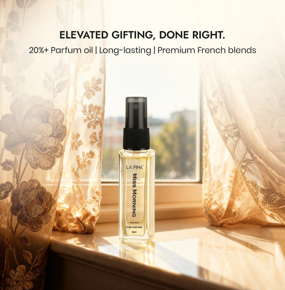 Perfume bottle on a windowsill with decorative curtains and scenic view.