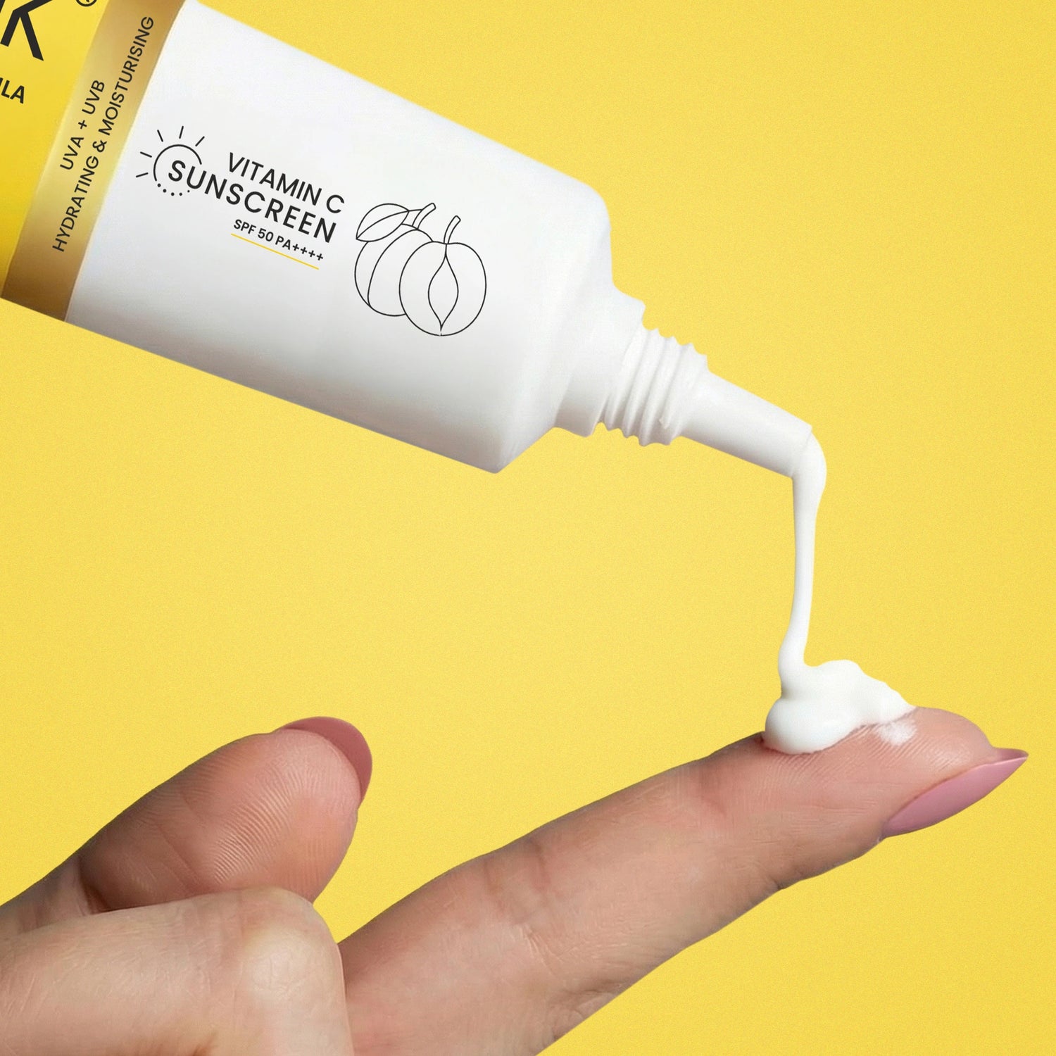 Vitamin C sunscreen being applied to a finger with a yellow background