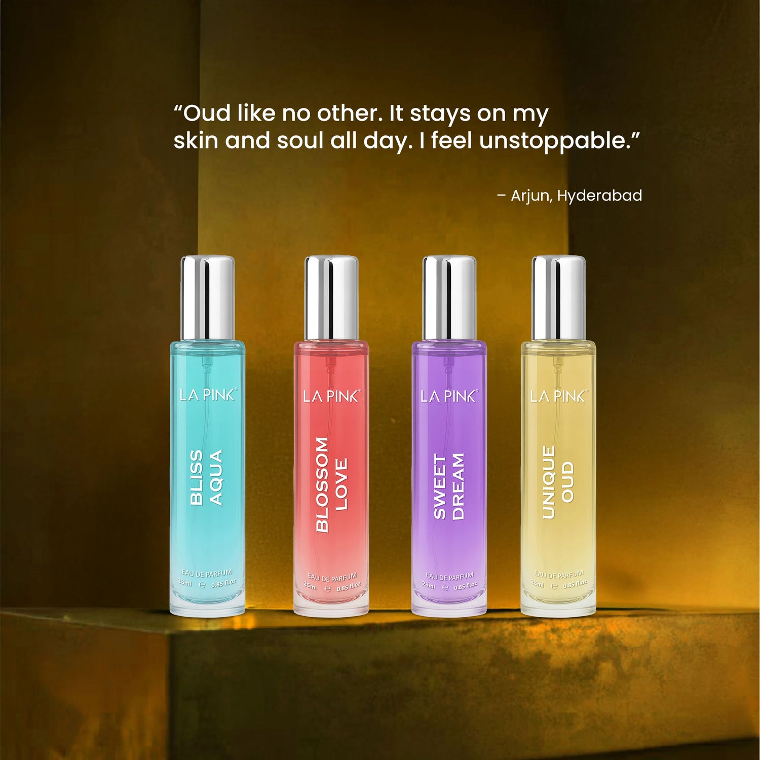 Four perfume bottles with colorful labels on a reflective surface
