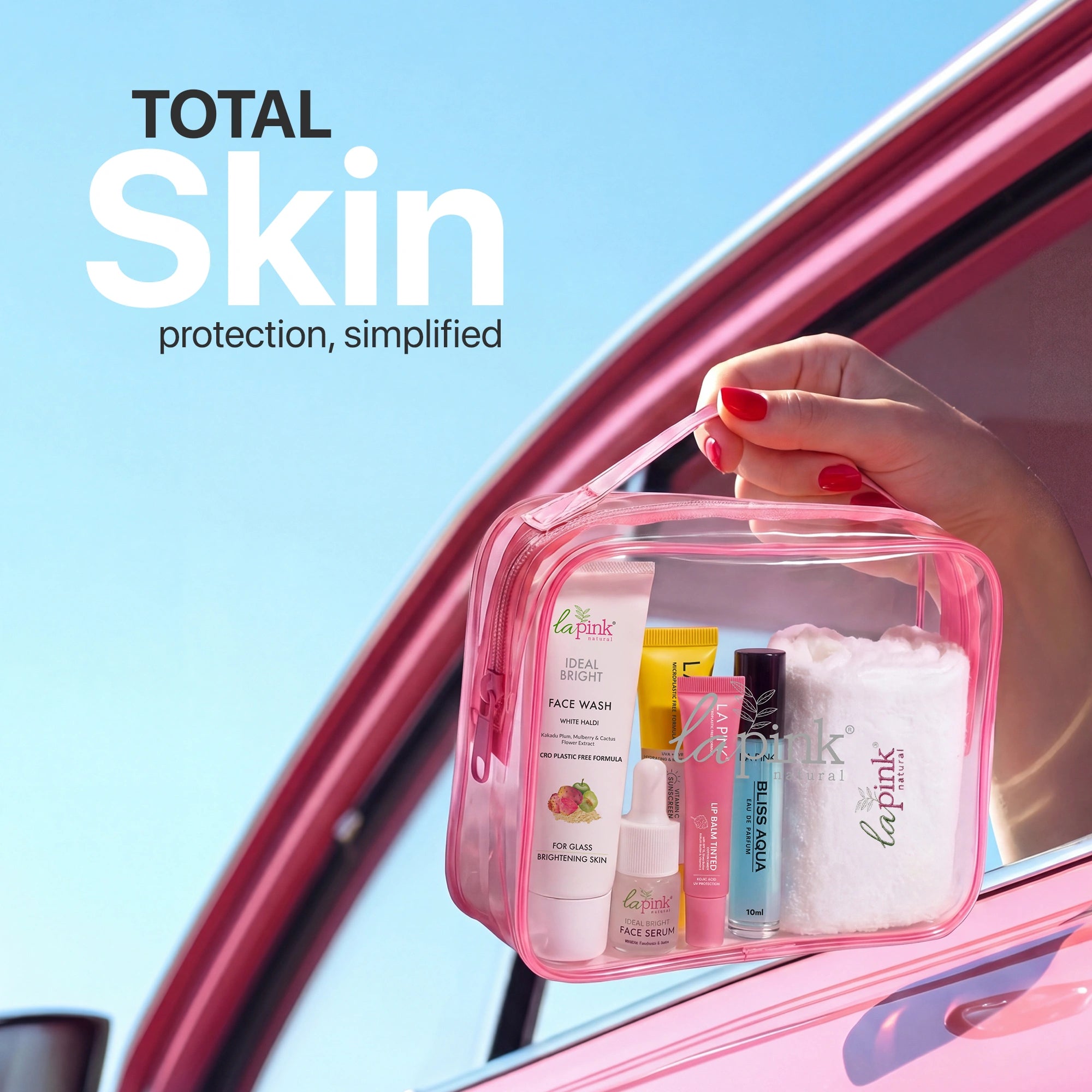 Pink skincare product set held by a hand with &