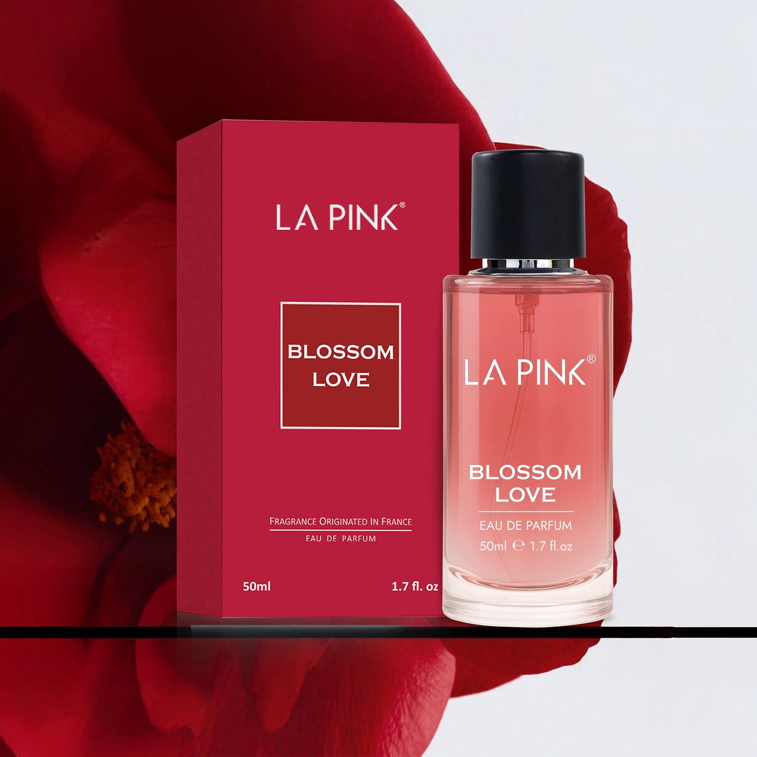 LA Pink Blossom Love perfume bottle and packaging on a red floral background