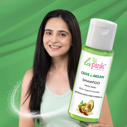 Woman with long hair holding a bottle of Lapink Olive &amp; Argan Shampoo against a green background