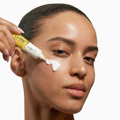 Woman applying cream to her face with a LA Pink tube