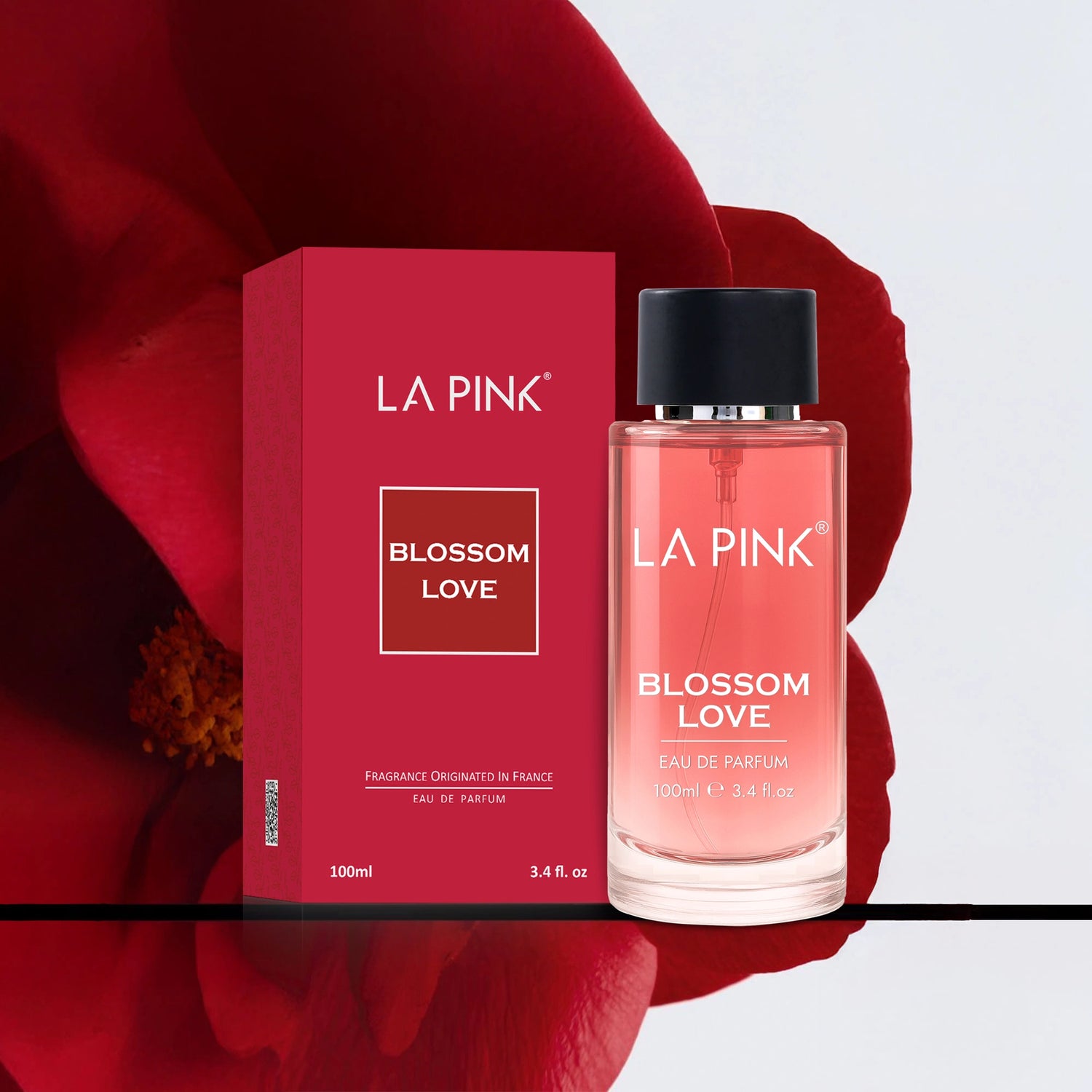 LA Pink Blossom Love perfume bottle and packaging on a red floral background