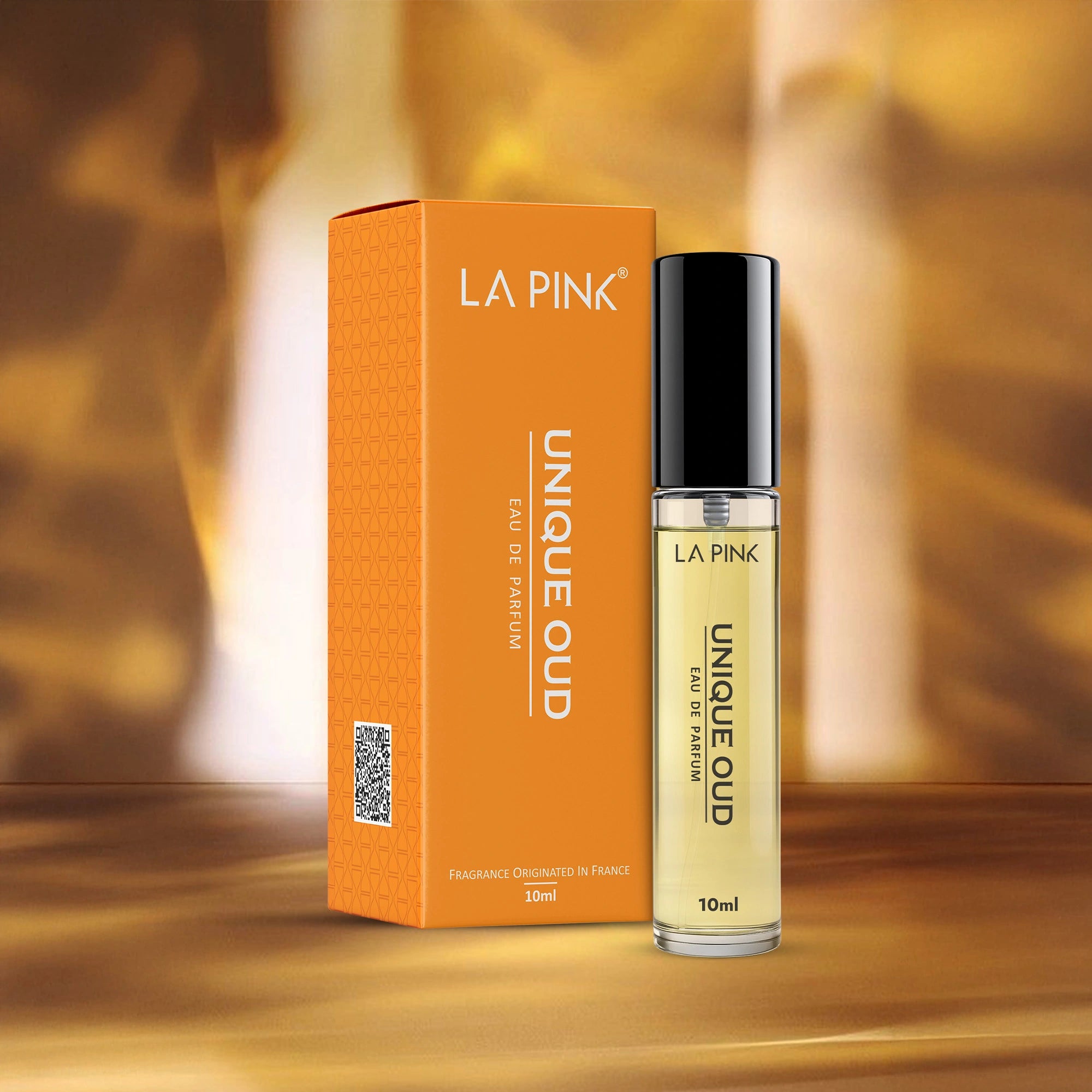 LA Pink Unique Oud perfume bottle and packaging on a wooden surface with a blurred background