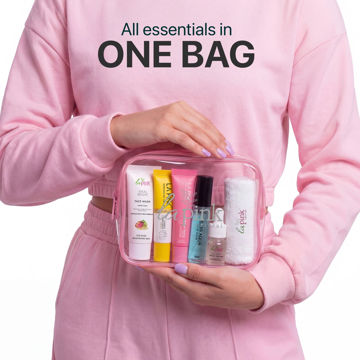 Person holding a clear travel bag with cosmetic products, wearing a pink outfit.