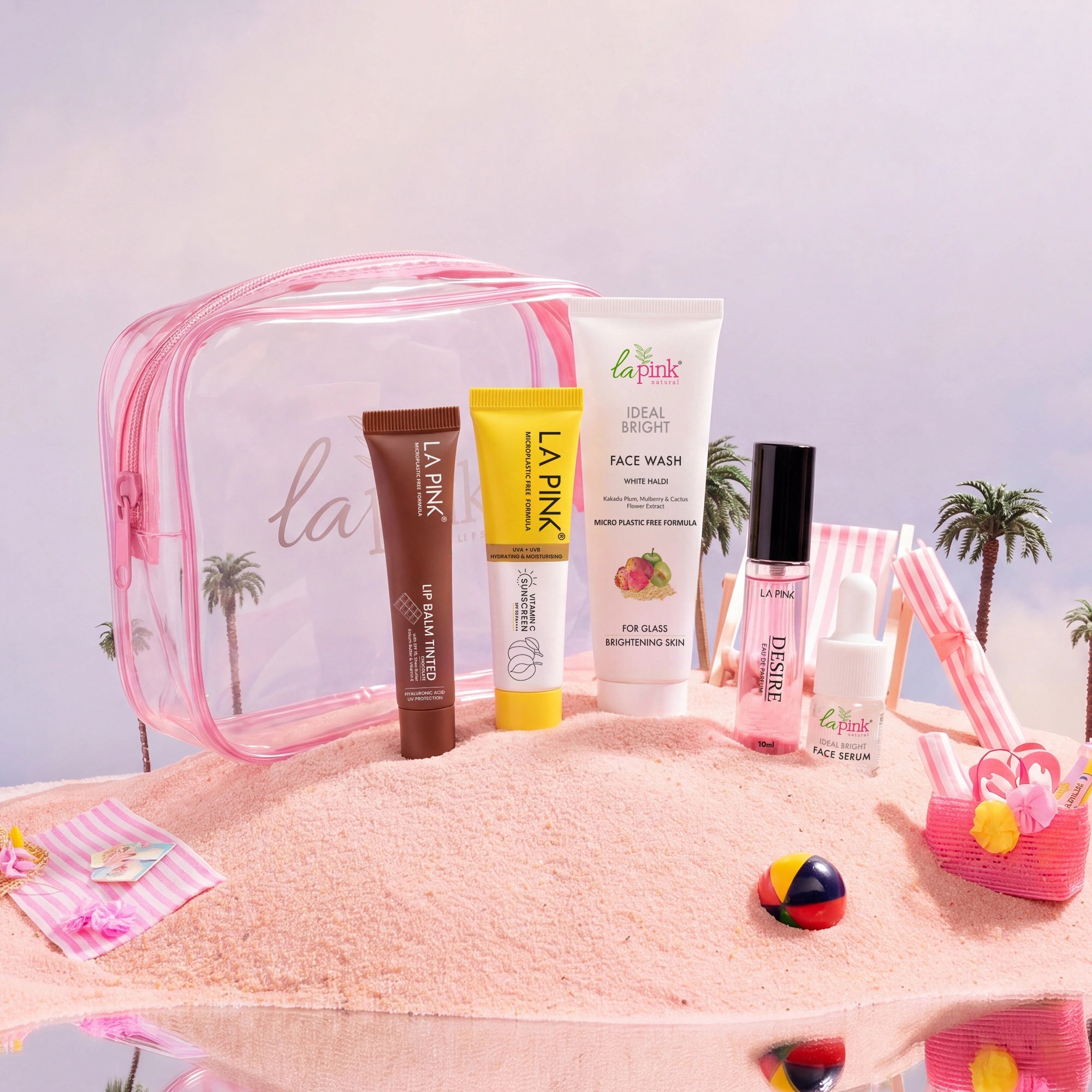 Set of La Pink skincare products on a sandy background with palm trees.