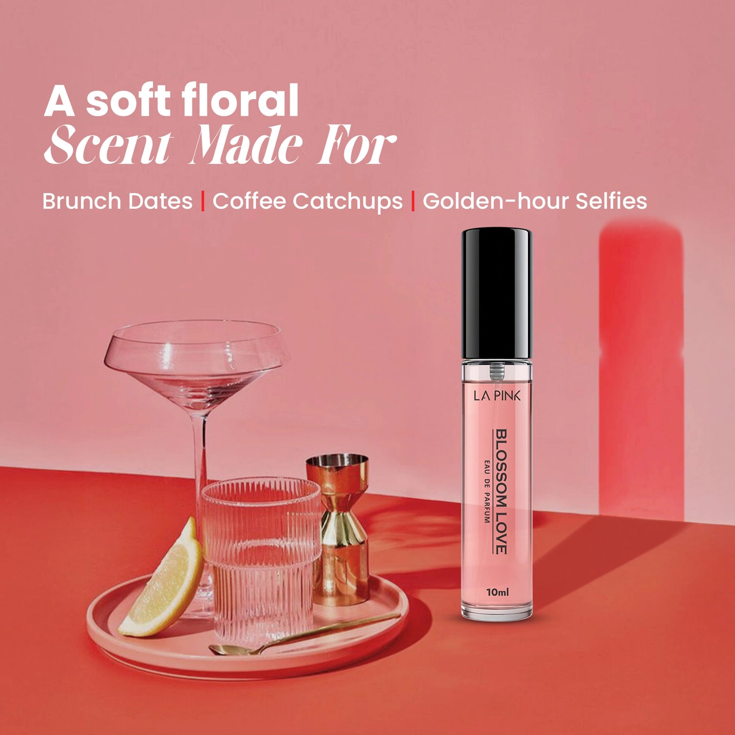 Pink lip gloss bottle on a red surface with a glass and lemon wedge, against a pink background.