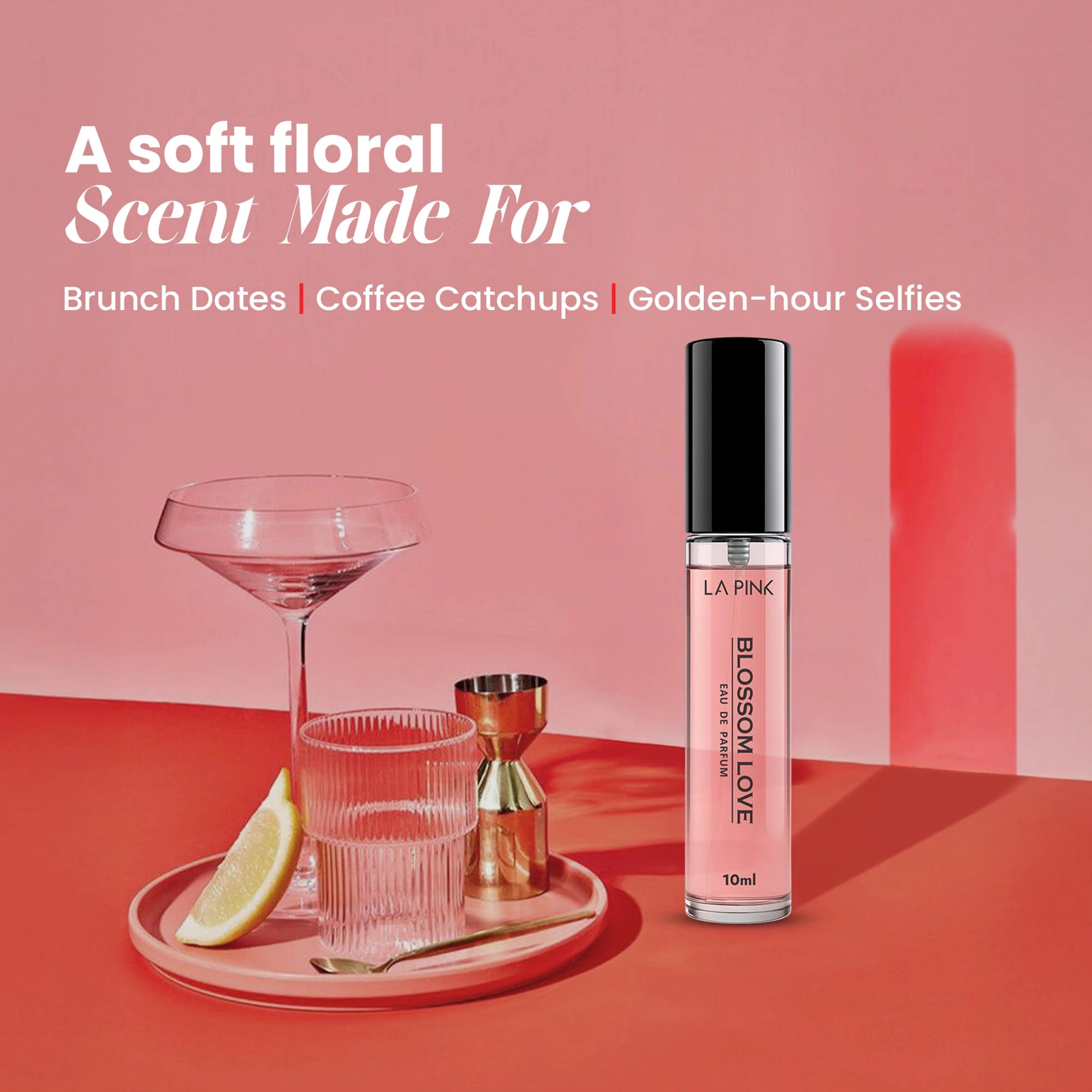Pink lip gloss bottle on a red surface with a glass and lemon wedge, against a pink background.