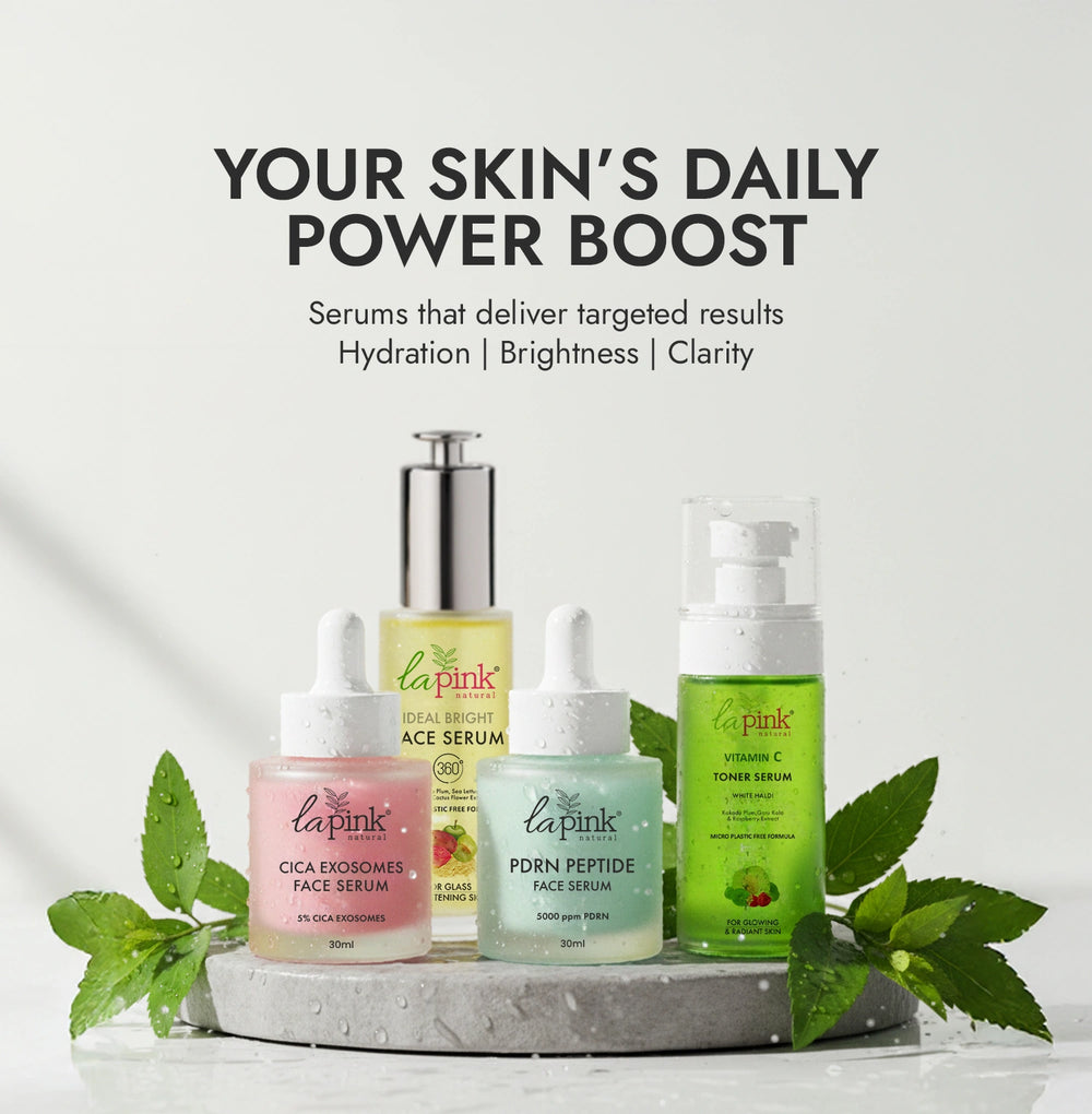 Collection of skincare serums with green leaves on a light background