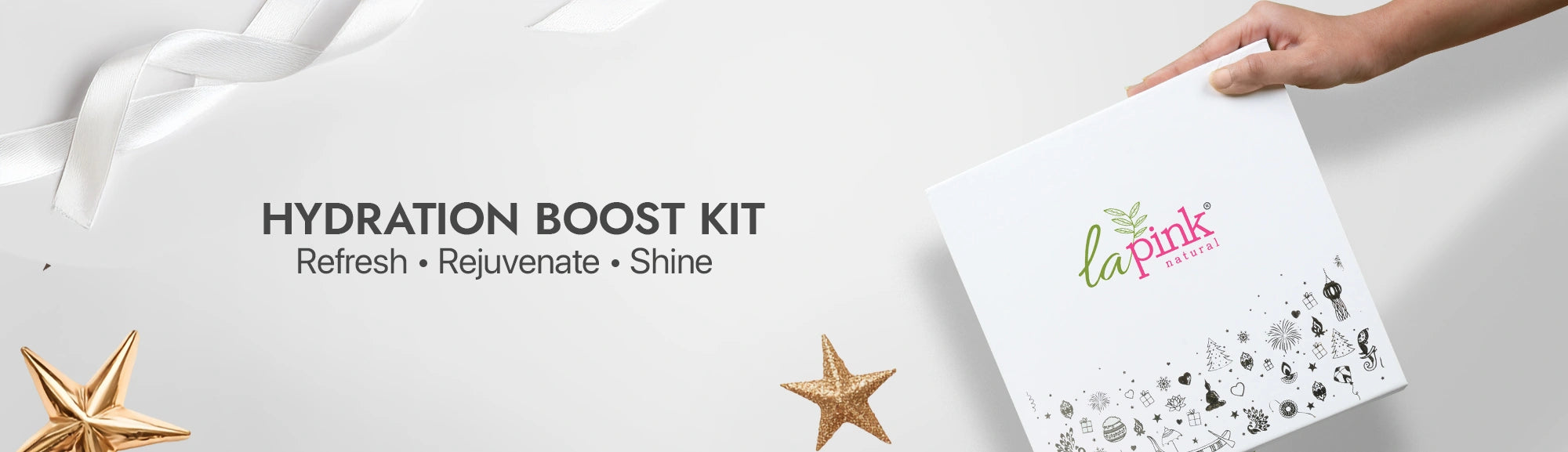 Hand holding a 'La Pink' hydration boost kit on a white background with decorative elements.