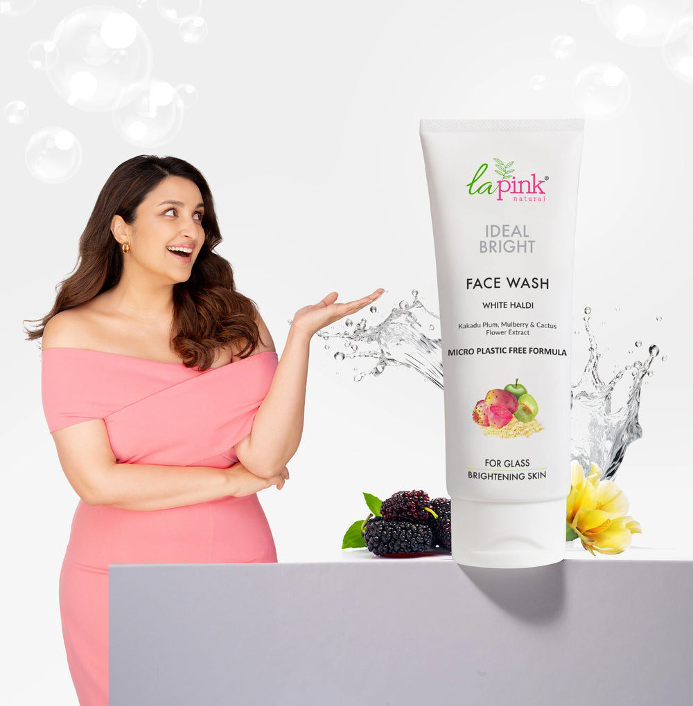 Woman in a pink dress pointing to a 'La Pink' face wash bottle on a white background