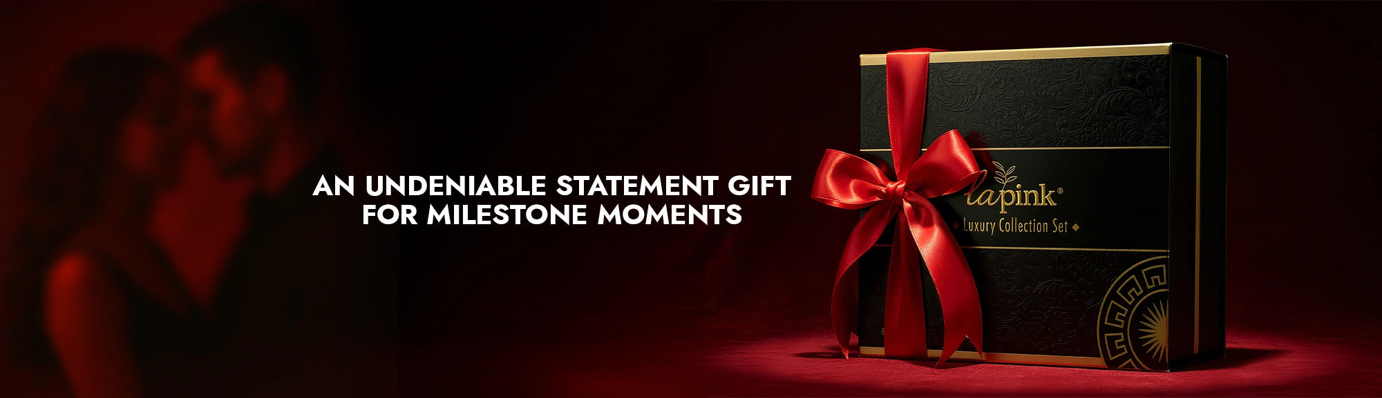 Gift box with a red ribbon on a dark background, featuring the brand 'La PINK'.
