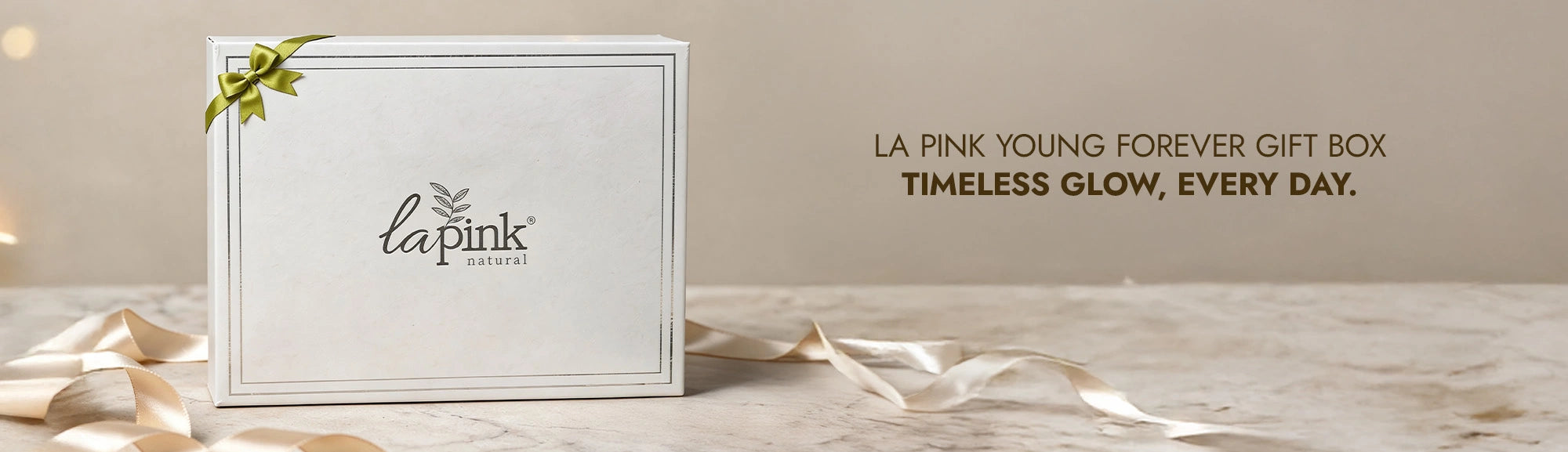 La Pink gift box with decorative ribbon on a neutral background