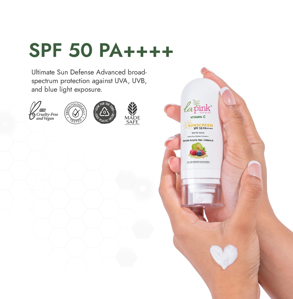 Hand holding a bottle of La Pink sunscreen with SPF 50 PA++++ on a white background