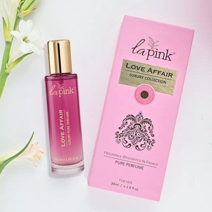 La Pink Love Affair perfume bottle and packaging with flowers on a light background