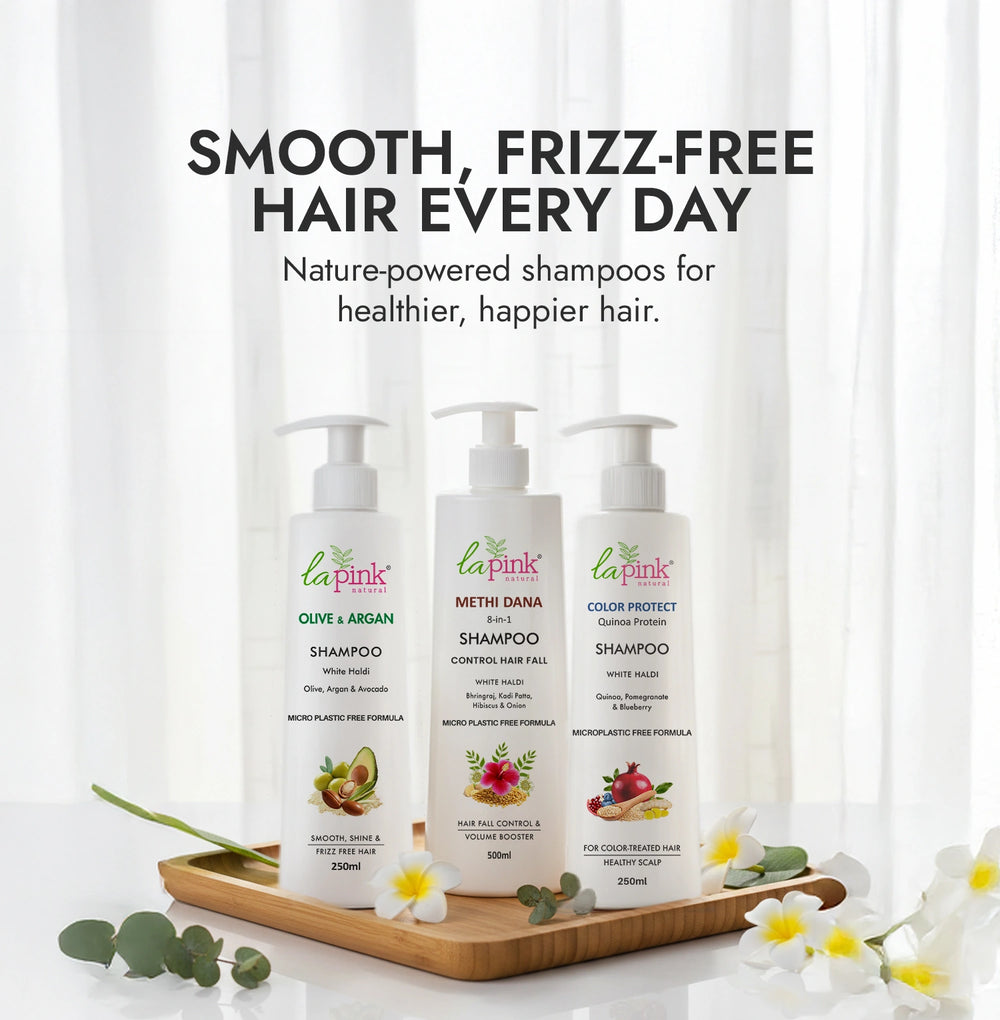 Three bottles of 'La Pink' shampoo on a wooden tray with a white curtain background.