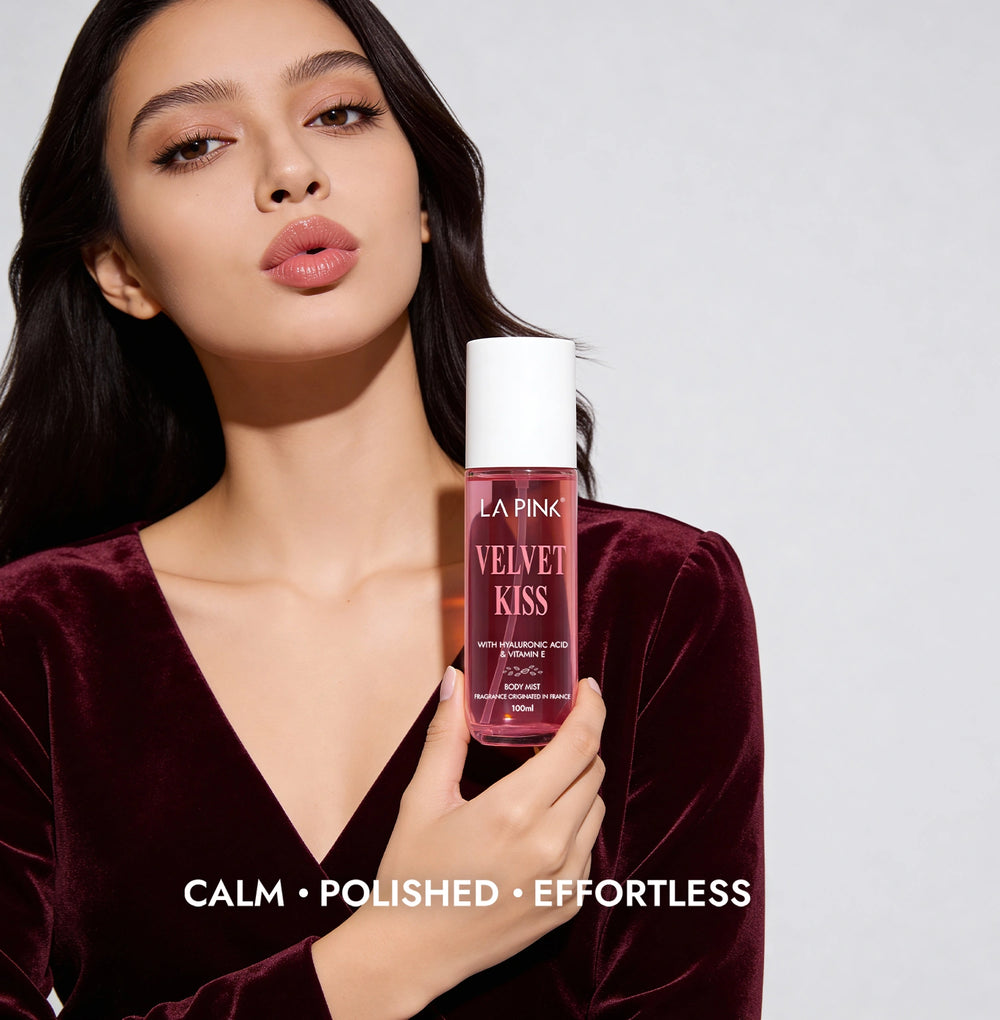 Woman holding a bottle of 'Pink Velvet Kiss' product against a plain background