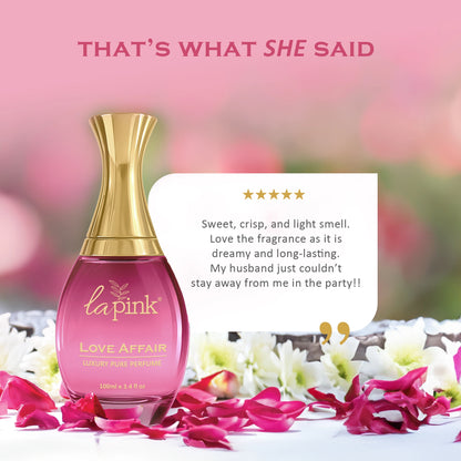Pink perfume bottle with gold cap on a pink background, surrounded by flowers.