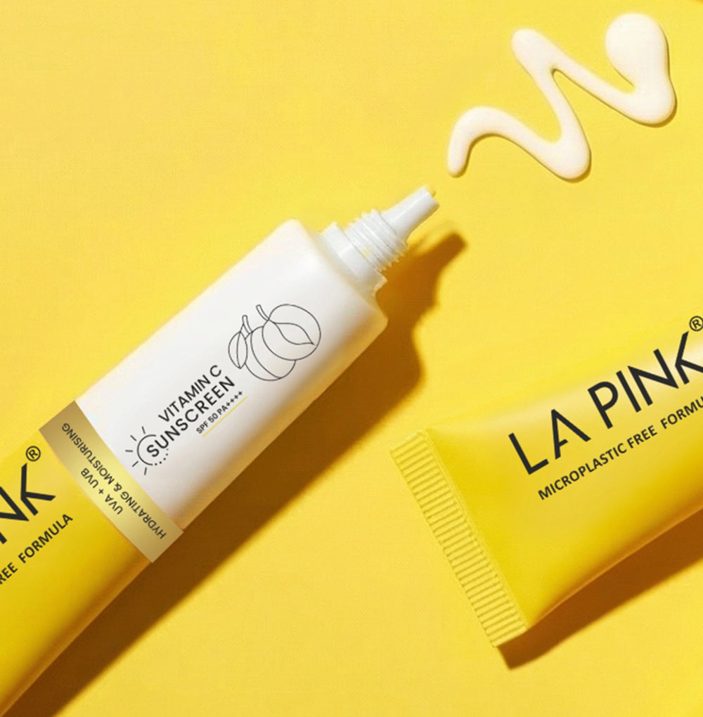 Vitamin C sunscreen tube and yellow container with 'La Pink' branding on a yellow background