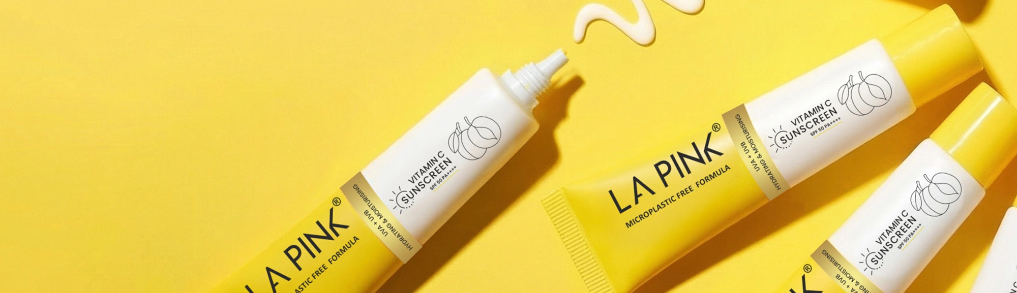 LA Pink skincare products on a yellow background